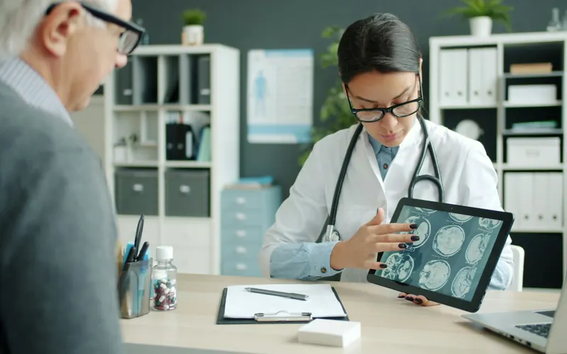 A doctor showing scan results on a tablet