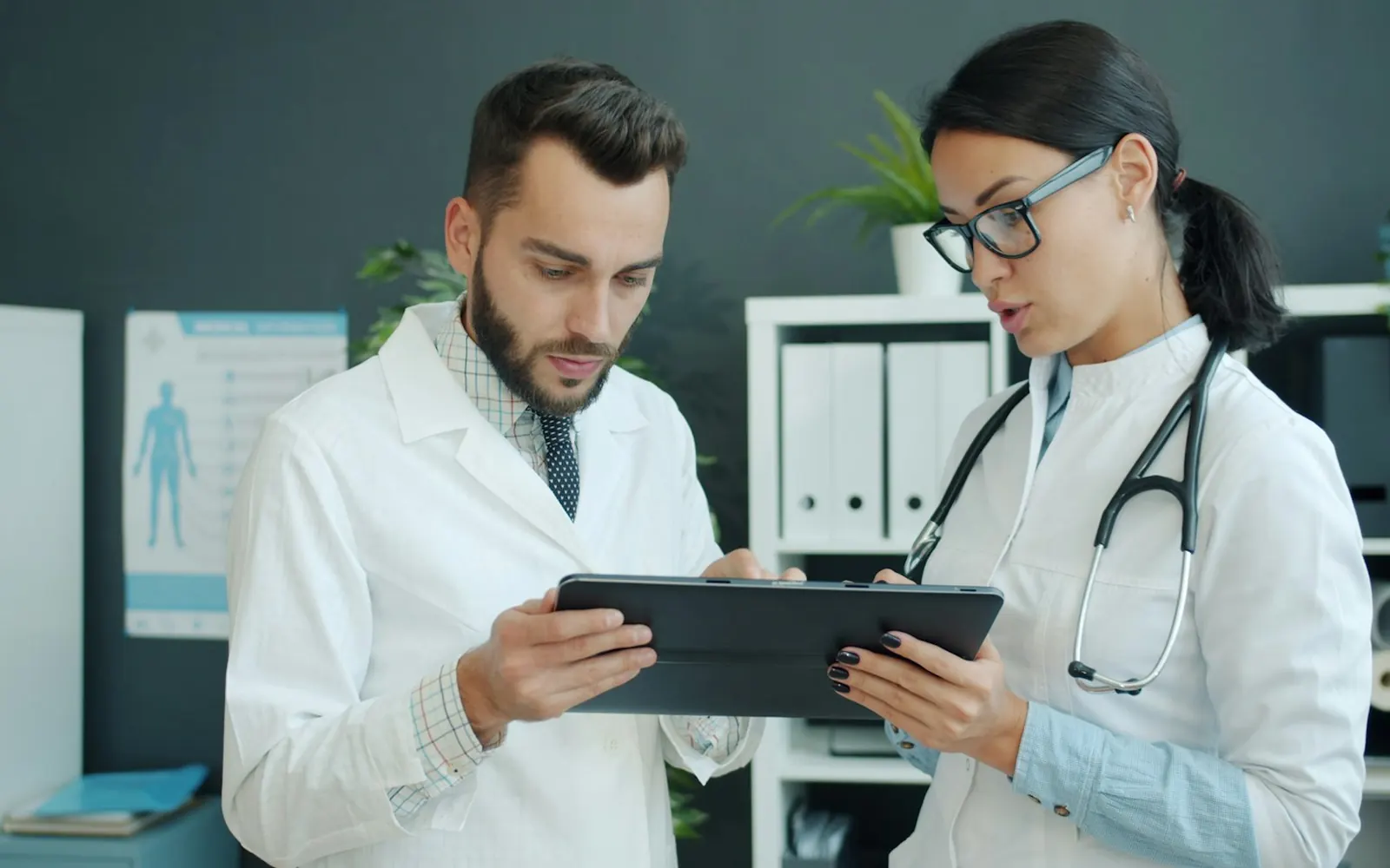 Two doctors reviewing information on a tablet