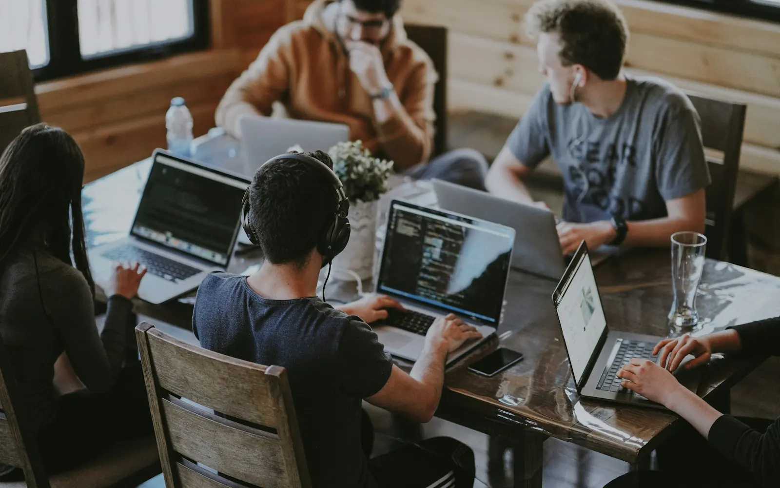 A software team collaborating on laptops around a shared table